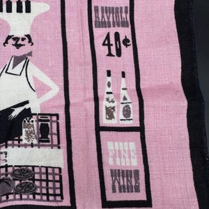 Pu&ograve; includere: Asciugamano da cucina rosa vintage con strisce verticali nere e illustrazioni. Presenta uno chef, bottiglie e le parole "Fine Wine" e "Raynoli 40&cent;". L'asciugamano ha un'estetica retr&ograve;.