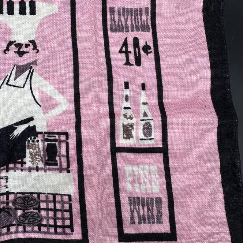 Pu&ograve; includere: Asciugamano da cucina rosa vintage con strisce verticali nere e illustrazioni. Presenta uno chef, bottiglie e le parole "Fine Wine" e "Raynoli 40&cent;". L'asciugamano ha un'estetica retr&ograve;.