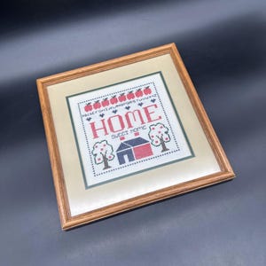 May include: A handmade wooden sign with the word "Welcome" in a whimsical font. It has a distressed white background and a dark brown frame, suitable for a front door or hallway. The sign is roughly 30 cm wide and 15 cm tall.