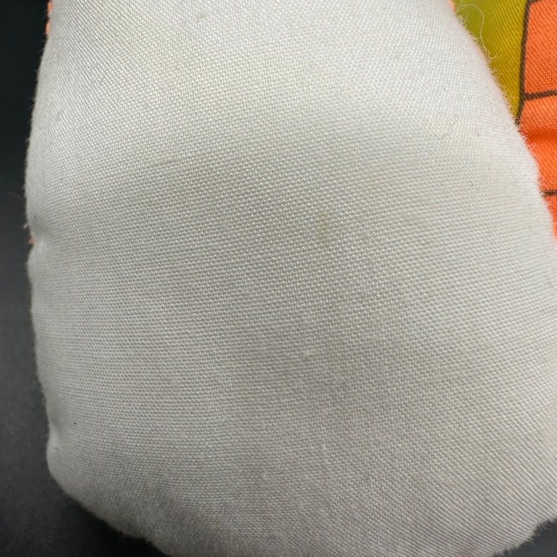 Peut inclure: Un coussin en tissu blanc avec un motif g&eacute;om&eacute;trique color&eacute; au dos. Le coussin est fait d'un tissu doux et textur&eacute;.