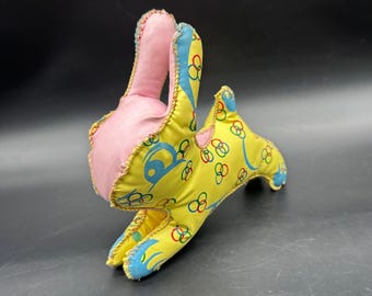 Conejo de peluche de vinilo vintage, color amarillo y rosa, juguete retro de mediados de siglo.