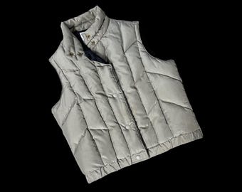 May include: A light gray quilted vest with a zipper closure and a stand-up collar.