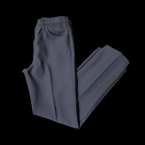Puede incluir: Un pantalón gris oscuro de pierna recta y corte clásico.