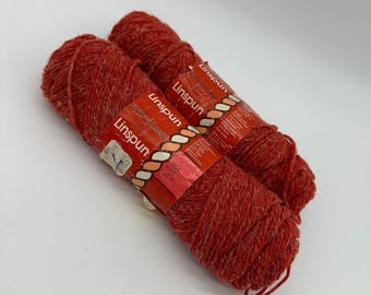 May include: Two skeins of red yarn labeled "Linspun" with the color number "24024 Rust" and the weight "2 oz (57 g)".