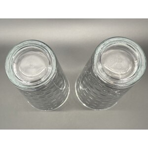 May include: Two clear glass drinking glasses with a textured pattern. The glasses are empty and appear to be new.