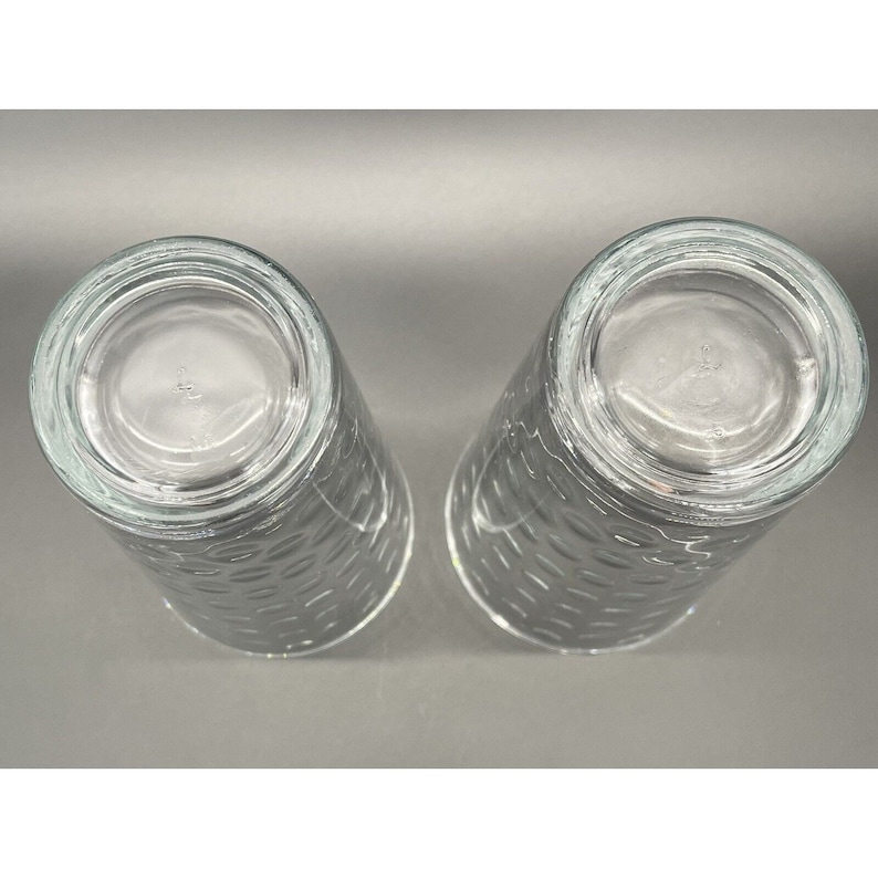 May include: Two clear glass drinking glasses with a textured pattern. The glasses are empty and appear to be new.