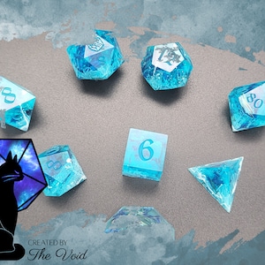 Può includere: Un set di dadi in resina blu e bianca con un dado d20 a tema galattico che presenta una silhouette di gatto nero. I dadi sono numerati da 6 a 20. Il set è creato da The Void.