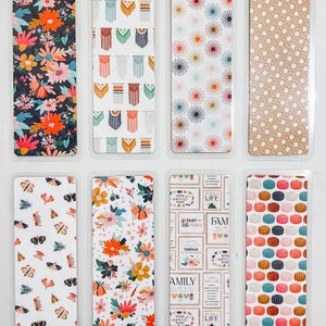 May include: Set of ten colorful bookmarks with various patterns. The patterns include floral, geometric, and polka dot designs. The bookmarks are all rectangular and approximately 2 inches wide and 6 inches long.