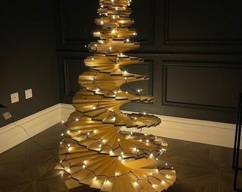 May include: A wooden Christmas tree with a spiral design and warm white lights. The tree is made of thin wooden slats and is decorated with a string of lights.