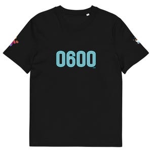 May include: Black t-shirt with the text "0600 AM" in a neon blue font. The shirt has a crew neck and short sleeves. Small graphics are visible on the sleeves.