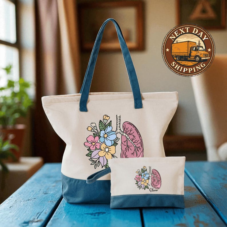 A white tote bag with a floral design and a smaller bag with a similar floral design are displayed on a blue wooden surface.