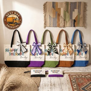 A collection of colorful tote bags with personalized names printed on them, arranged on a wooden surface.