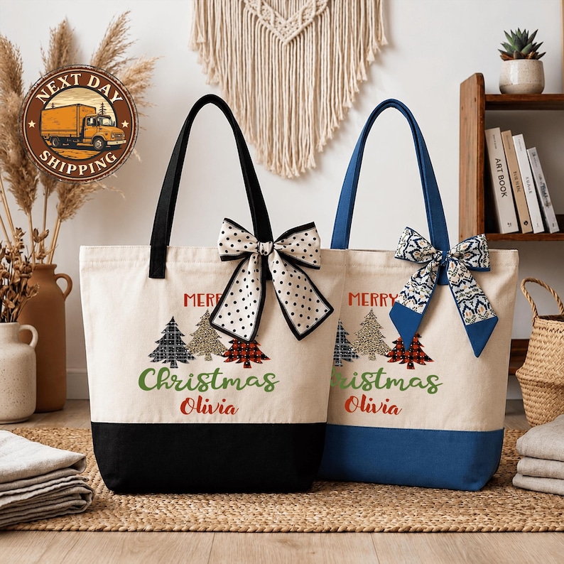 two tote bags with Christmas tree designs and personalized names on them, placed on a woven mat.