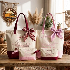 a collection of four tote bags and a small bag, all with the same design and branding, placed on a wooden table.