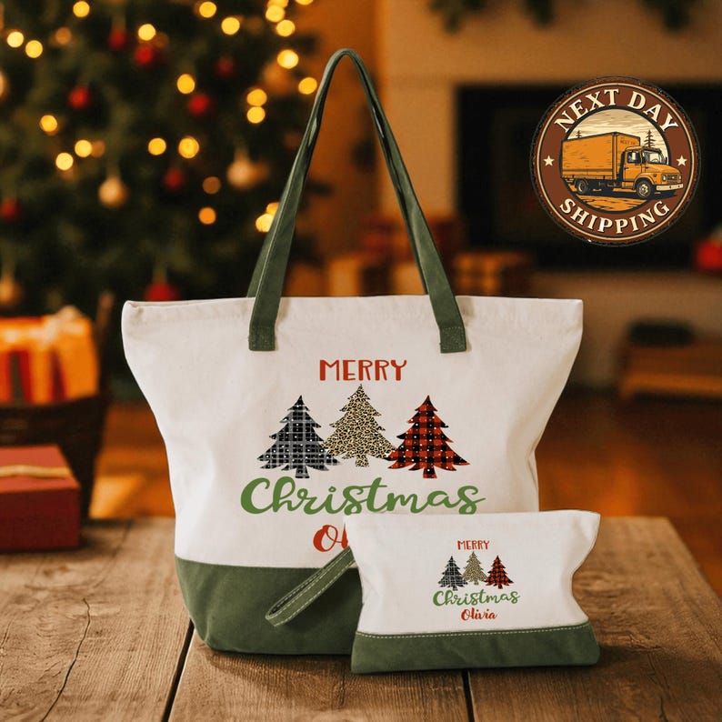 A white tote bag with a green handle and a smaller bag with a similar design are displayed on a wooden surface, with a Christmas tree and a truck in the background.