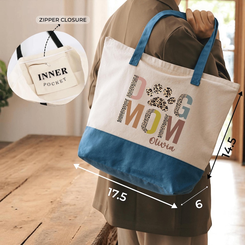 A person is holding a tote bag with a dog paw print design and the text "Dog Mom Olivia" printed on it.
