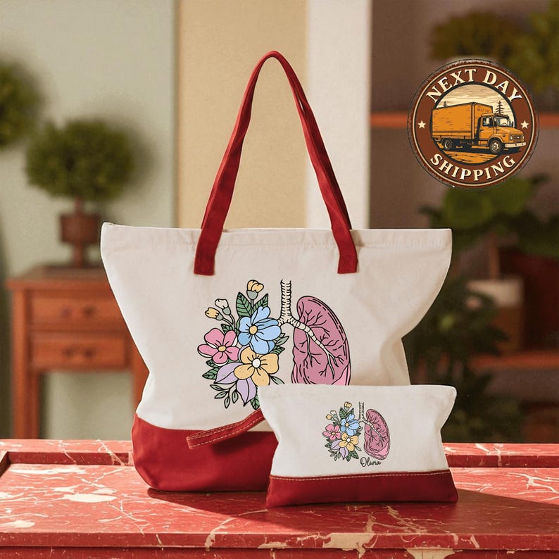 A large white tote bag with a red handle and a smaller white pouch featuring a pink and blue floral design are displayed on a red marble countertop.