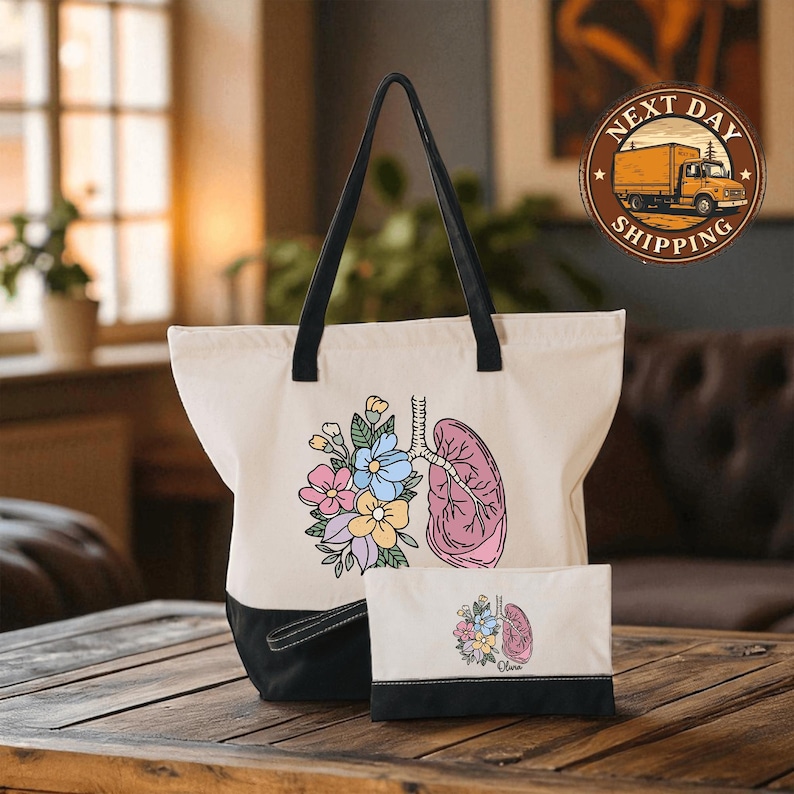 A white tote bag with a colorful floral design and a pink lung illustration, placed on a wooden surface.