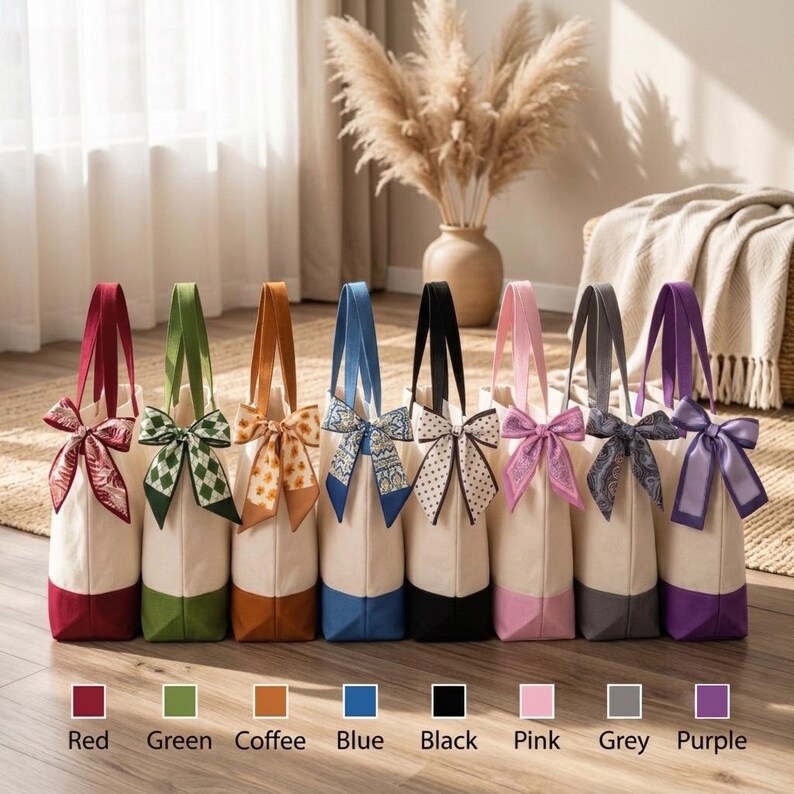 A row of colorful tote bags with bows, each with a different color, displayed on a wooden floor.