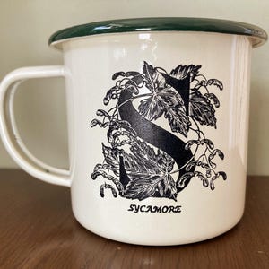 Taza de camping en lata esmaltada con la letra S, inicial del árbol, sicómoro