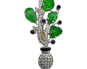 Spilla europea in platino e oro con design Art Déco a motivi floreali, impreziosita da diamanti e colori.
