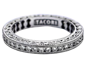 Könnte beinhalten: Ein silberner Ring mit einem zarten, mit Diamanten besetzten Design. Der Ring ist mit dem Wort "Tacori" beschriftet.