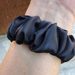 May include: A black satin scrunchie for hair.