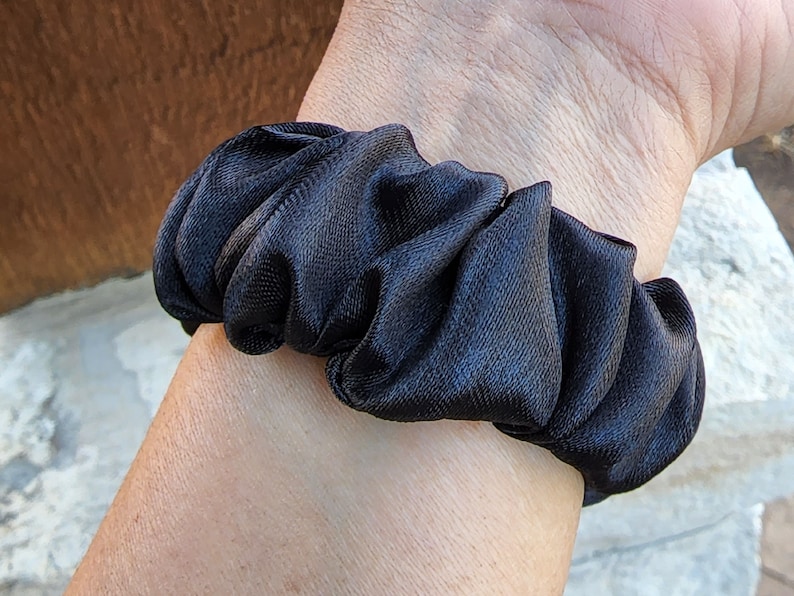 May include: A black satin scrunchie for hair.