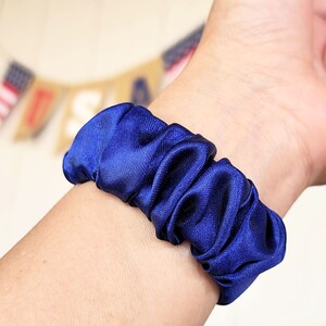 May include: A blue satin scrunchie for hair.