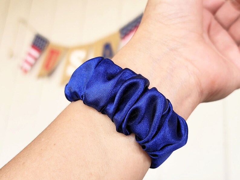 May include: A blue satin scrunchie for hair.