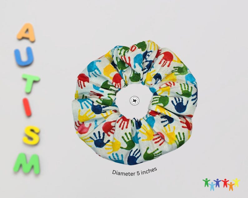 Puede incluir: Un scrunchie blanco con huellas de manos de colores. El scrunchie tiene un di&aacute;metro de 5 pulgadas.
