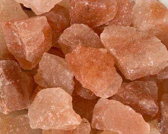 Puede incluir: Primer plano de un montón de rocas de sal rosa del Himalaya. Las rocas de sal son de varios tamaños y formas, con una textura rugosa y natural.