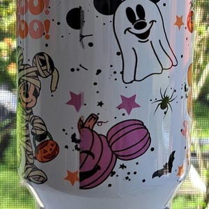 Puede incluir: Vaso blanco con tem&aacute;tica de Halloween. El dise&ntilde;o incluye calabazas de dibujos animados, fantasmas, murci&eacute;lagos, ara&ntilde;as, estrellas y la palabra "Boo!". El vaso tiene un dise&ntilde;o envolvente con un acabado brillante.