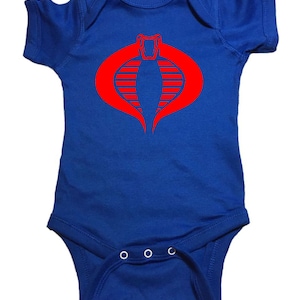 May include: A royal blue baby onesie with a red Cobra logo from the G.I. Joe cartoon series.