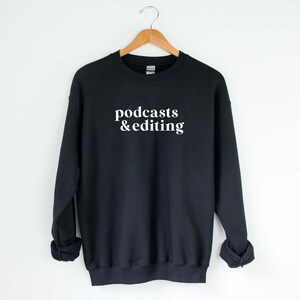 K&ouml;nnte beinhalten: Schwarzer Pullover mit wei&szlig;em Text, der "podcasts & editing" lautet.