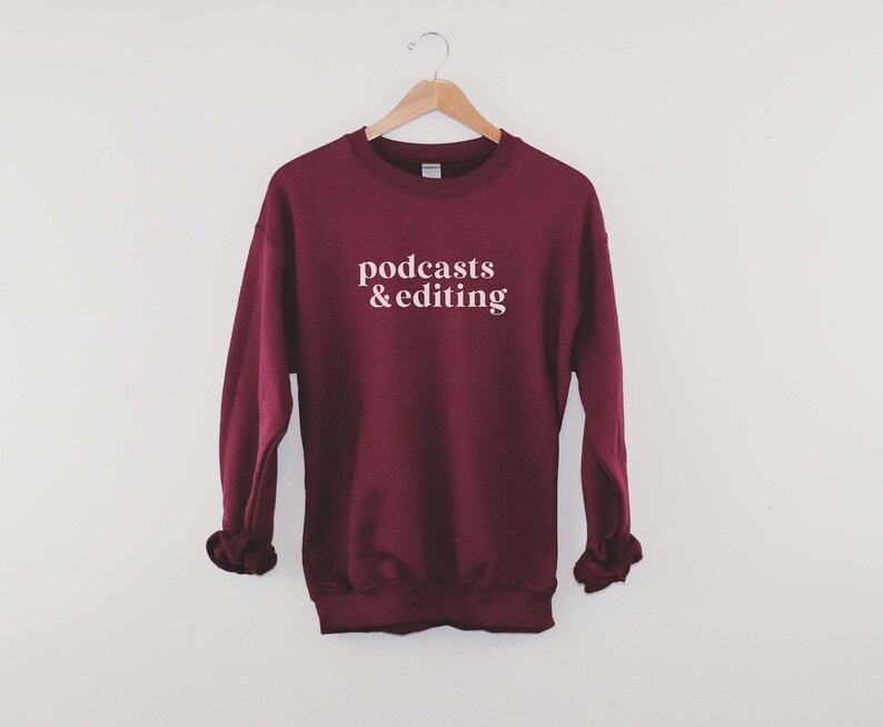 K&ouml;nnte beinhalten: Ein weinroter Pullover mit dem Text "podcasts & editing" in Wei&szlig;.