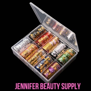 May include: A clear plastic organizer filled with colorful nail art foil in various metallic shades. The foil rolls are in a clear plastic container with a hinged lid. The text "JENNIFER BEAUTY SUPPLY" is at the bottom.