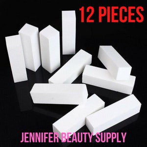 May include: A collection of twelve white nail buffer blocks, arranged on a black surface. The blocks are rectangular and square-edged, with the text "12 PIECES" in red and "JENNIFER BEAUTY SUPPLY" in pink.