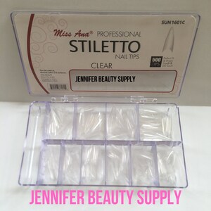 May include: Clear stiletto nail tips by Miss Ana Professional, in a divided plastic container. The box reads "Jennifer Beauty Supply" and includes 500 tips in sizes 0-9. The tips are designed for almond, coffin, and ballerina nail shapes.