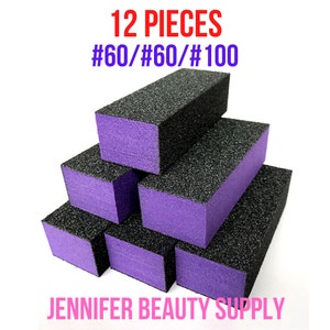 May include: A stack of 12 rectangular nail buffer blocks. The blocks have a black abrasive surface and purple sides. The text "12 PIECES #60/#60/#100" is in red and purple. The text "JENNIFER BEAUTY SUPPLY" is in pink.
