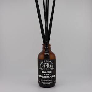 May include: A brown glass reed diffuser bottle with black reeds. The label reads "Sage and Rosemary Reed Diffuser" and includes the text "Project Happiness". The bottle contains 3.4 fl oz / 100 ml of fragrance.