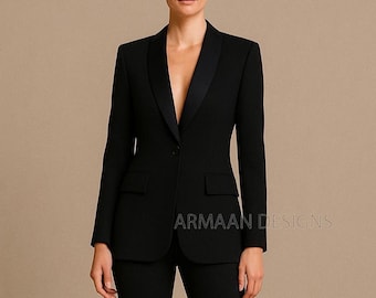 May include: A black blazer with a satin lapel, single-button closure, and two front pockets. The blazer is part of a suit and is worn by a person. The text "ARMAAN DESIGNS" is visible on the lower right.