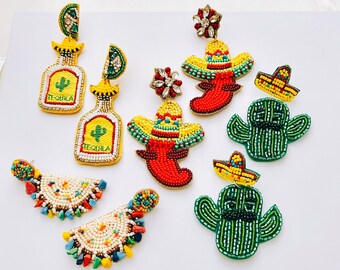 May include: A set of 8 colorful beaded earrings featuring various Mexican-inspired designs, including cacti, sombreros, tequila bottles, and chili peppers. The earrings are handmade and feature a variety of colors, including green, red, yellow, and blue.