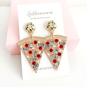 May include: Gold-toned pizza slice earrings with red, blue, and pink gemstones. The earrings have a gold-toned circular top with green accents. The earrings are displayed on a white card with the text "Goldenriverus Jewelry & Accessories".