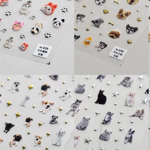 Könnte beinhalten: Vier Bögen mit selbstklebenden Nagelstickern, die verschiedene Katzen- und Hundeporträts, kleine Tiergesichter sowie metallische Stern-, Herz- und Pfotenmotive zeigen. Jeder Bogen enthält ein weißes Etikett mit der Aufschrift ta-229, ta-230, ta-232 oder ta-233.