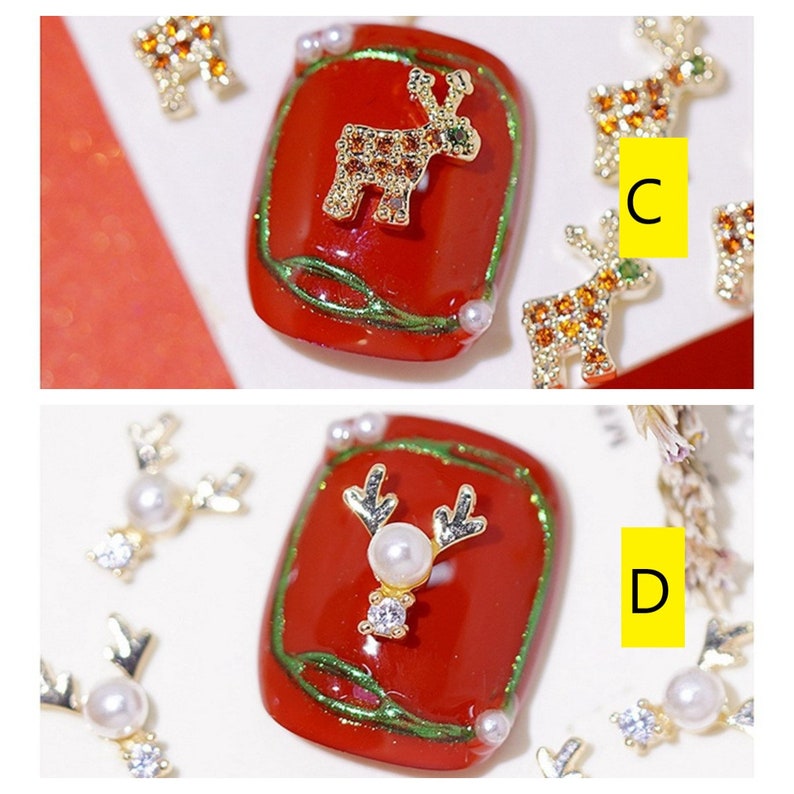 Pode incluir: Duas decora&ccedil;&otilde;es de unhas vermelhas com desenhos de renas douradas. Uma rena tem uma p&eacute;rola e strass, a outra tem strass. As decora&ccedil;&otilde;es s&atilde;o cercadas por pingentes de rena dourados soltos com p&eacute;rolas e strass.