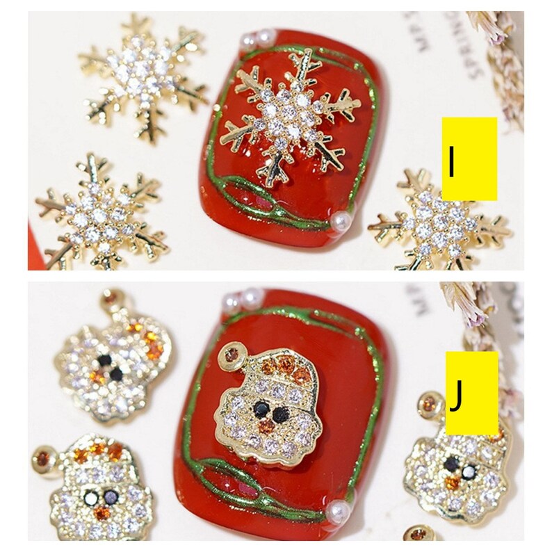 Pode incluir: Um conjunto de pingentes de unha de Natal dourados com um Papai Noel, flocos de neve e um boneco de neve. Os pingentes s&atilde;o decorados com strass e s&atilde;o perfeitos para adicionar um toque festivo &agrave;s suas unhas.