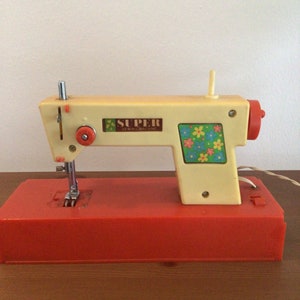 Máquina de coser infantil vintage de los años 70 con batería eléctrica.