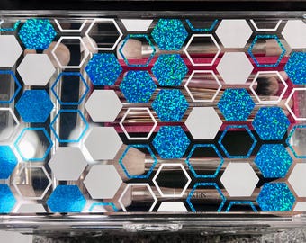 May include: A clear acrylic makeup organizer with a blue and white honeycomb pattern. The organizer has multiple compartments for storing makeup brushes.