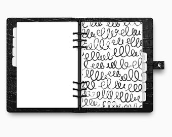 May include: Black leather planner with a textured finish, open to display blank white pages and a page with black squiggly lines. The planner has a ring binder and labeled dividers.